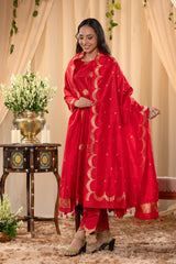 A woman in a traditional red salwar suit and red banarasi dupatta