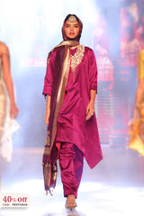 Woman wearing a design silk purple suit with a long scarf, standing on a runway with offer text of 40% off