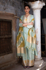 Model wearing a powder blue Handloom silk suit set with golden accents on Dupatta