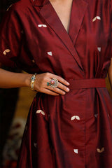 Woman in a maroon Indo-Western dress made with zari motifs