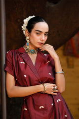 Woman in a maroon Indo-Western dress made with zari motifs