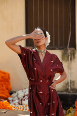 Woman in a maroon Indo-Western dress made with zari motifs