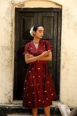 Woman in a maroon Indo-Western dress made with zari motifs
