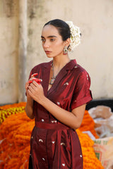 Woman in a maroon Indo-Western dress made with zari motifs