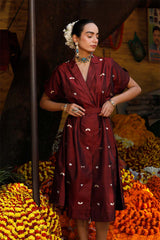 Woman in a maroon Indo-Western dress made with zari motifs