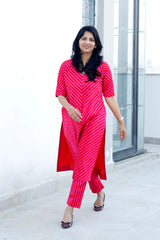 A woman wearing a bright pink co-ord set outfit with a patterned top and pleated pants