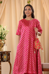 A woman in a pink traditional kurti co-ord set, standing in a decorated indoor setting.