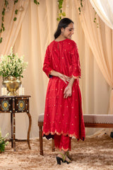 A woman in a traditional red salwar suit and red banarasi dupatta