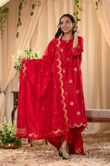 A woman in a traditional red salwar suit and red banarasi dupatta