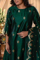 A woman in a traditional bottle green salwar suit and green banarasi dupatta