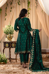 A woman in a traditional bottle green salwar suit and green banarasi dupatta