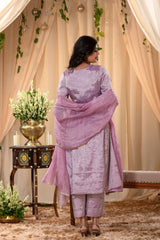 A woman in a lilac pink traditional salwar suit and lilac banarasi dupatta