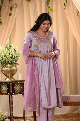 A woman in a traditional lilac pink salwar suit and lilac banarasi dupatta