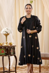A woman in a black Indo-Western dress, paired with a matching coat featuring pichwai motifs.