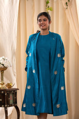 A woman in a blue Indo-Western dress with a matching coat is standing in front.