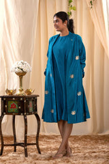 A woman in a blue Indo-Western dress with a matching coat is standing in front.