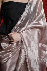 Person wearing a black dress with a pink satin shawl over a red background