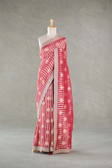Red patterned saree on a mannequin against a gray background