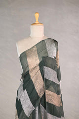 sage green gold and silver checkered organza silk tissue saree draped on a mannequin against a gray background