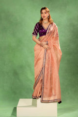 Women Wearing Peach Tissue Silk Saree, party wear saree, gold and silver zari buti and rust brocade pallu with scalloped lace border.