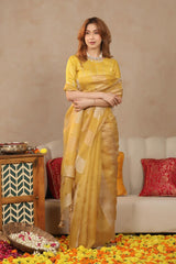 Women Wearing Yellow Organza Silk Saree for Haldi having crushed tissue gold and silver zari woven stripes and pitta zari blouse work.