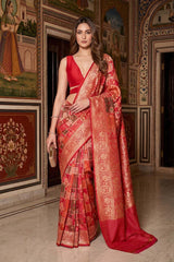 Woman wearing a Red Banarasi Katan Silk Rangkat Saree featuring woven Mughal miniature florals and Persian jaal artistry, standing in a heritage setting