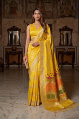 Women draped in a Yellow Kadhwa Handloom Katan Silk Banarasi Saree featuring gold and silver zari pakshi motifs in a leheriya pattern and a Meenakari border.