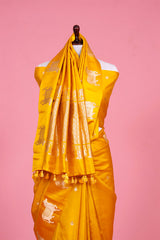 A yellow Banarasi silk saree with Pichwai zari border for Navratri, Diwali, Durga Puja, and weddings, displayed on a mannequin. 