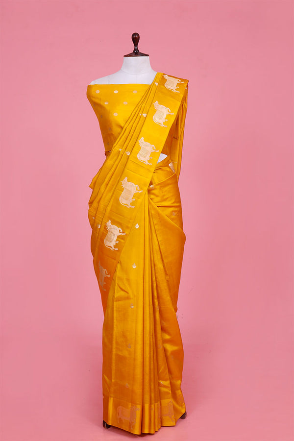A yellow Banarasi silk saree with Pichwai zari border for Navratri, Diwali, Durga Puja, and weddings, displayed on a mannequin. 