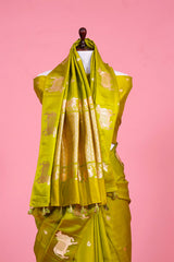 A henna green Banarasi silk saree with zari border for Navratri, Diwali, Durga Puja, and weddings, displayed on a mannequin. 