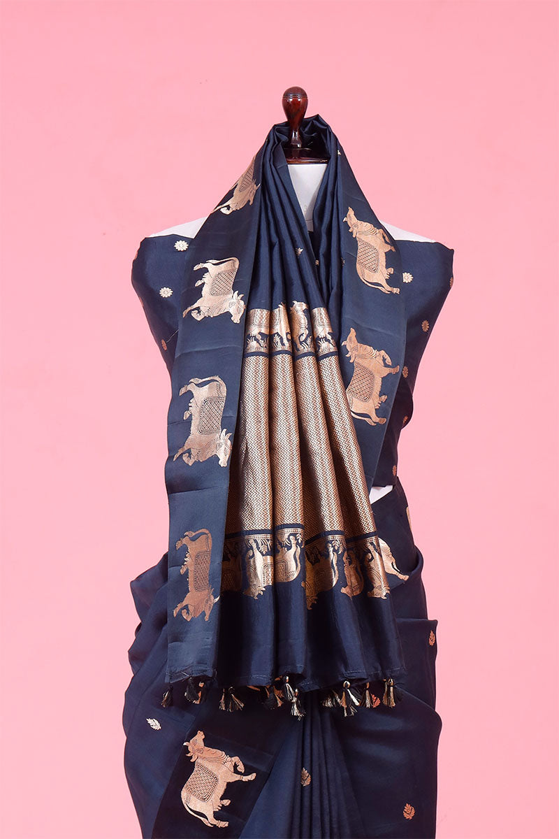 A dark grey Banarasi silk saree with Pichwai border for Navratri, Diwali, Durga Puja, and weddings, displayed on a mannequin. 