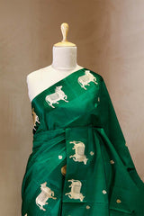 A green Banarasi silk saree with gold zari border for Navratri, Diwali, Durga Puja, and weddings, displayed on a mannequin. 