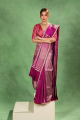 Woman wearing a purple saree against a green background