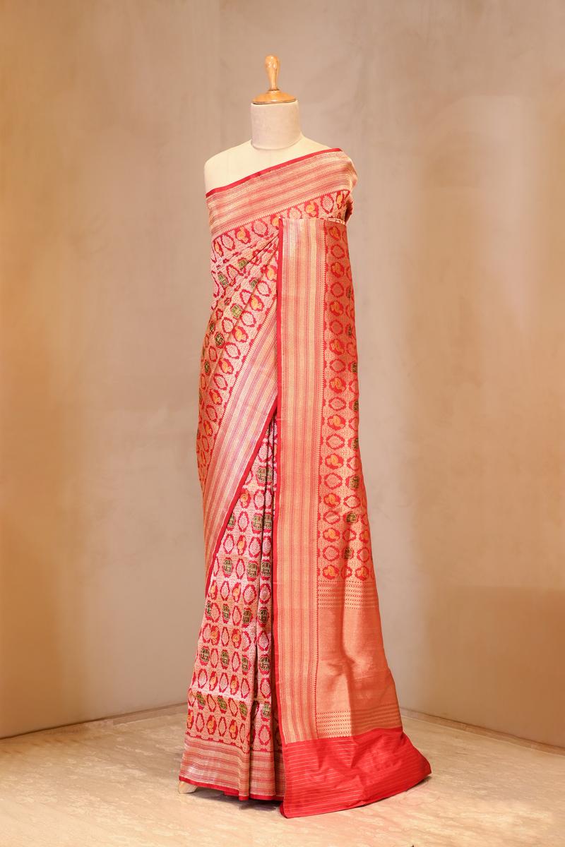 A red shikargah Banarasi silk saree on dummy
