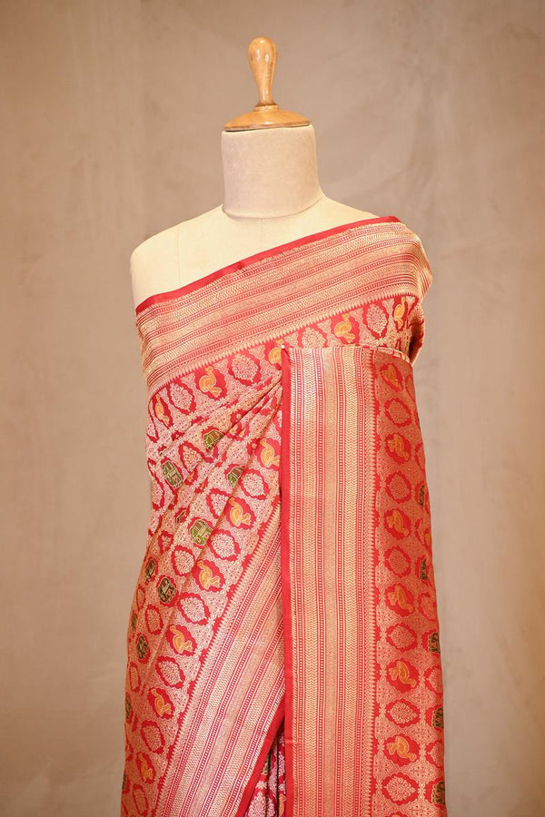 A red shikargah Banarasi silk saree on dummy