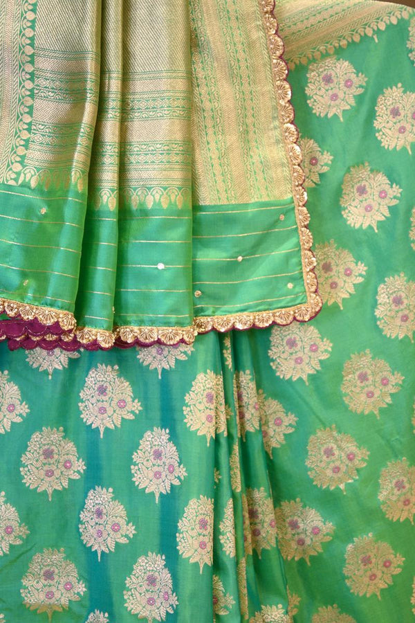 A sea green Banarasi silk saree with zari motifs on dummy