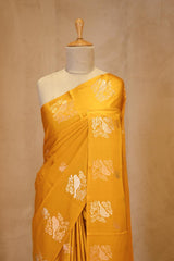 A yellow Banarasi silk saree on dummy