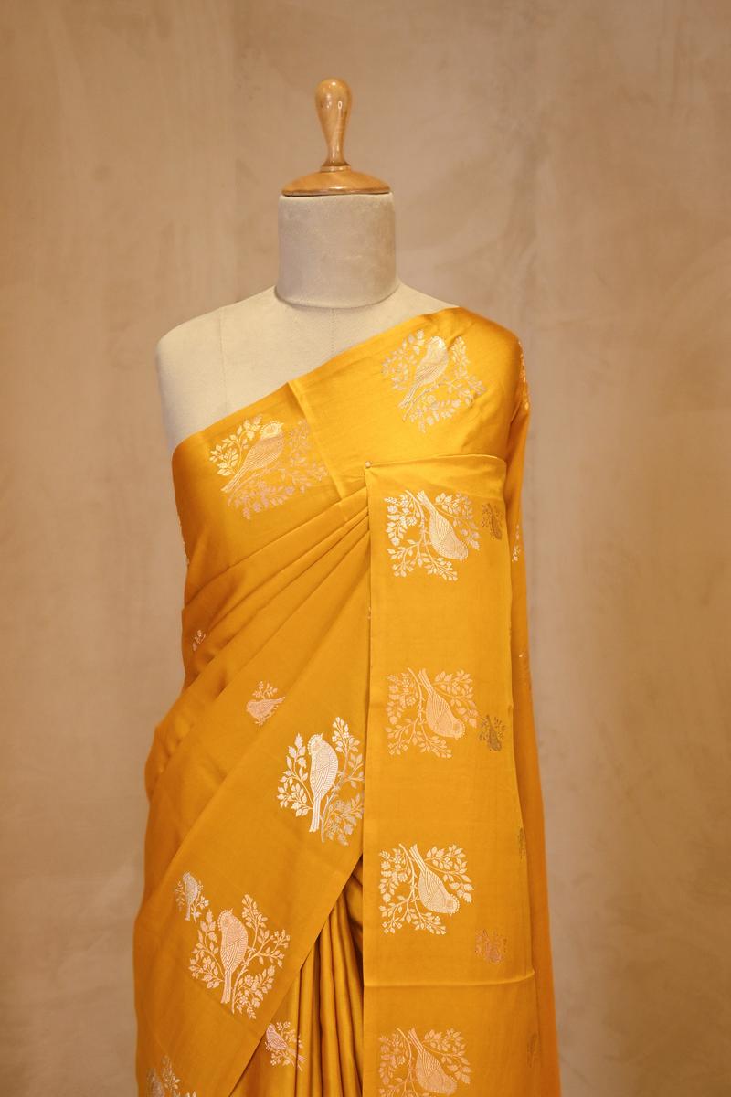 A yellow Banarasi silk saree on dummy