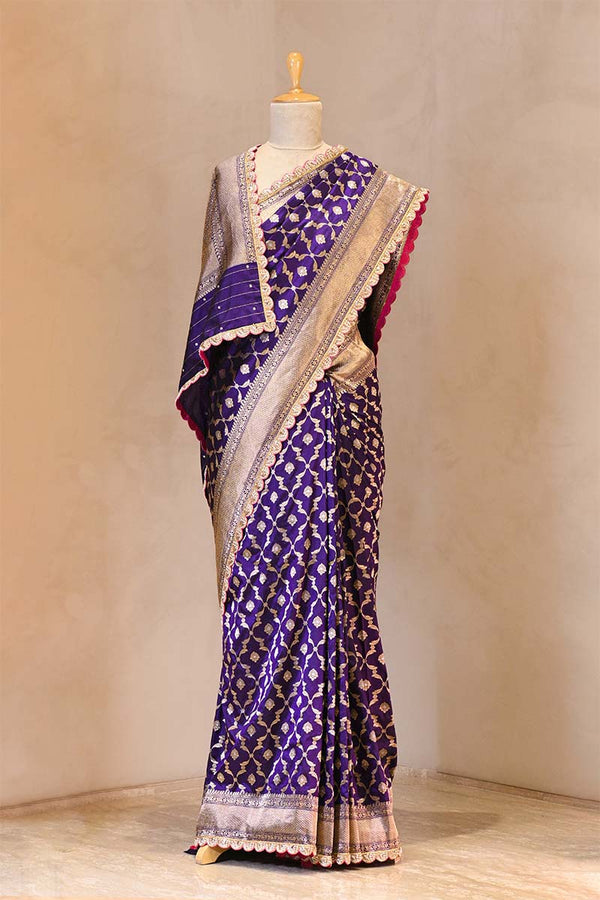 Purple patterned saree on a mannequin against a plain background