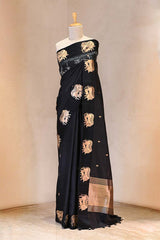 Black saree with gold embroidery on a mannequin against a neutral background