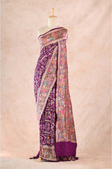 Purple saree with intricate patterns on a mannequin against a beige background