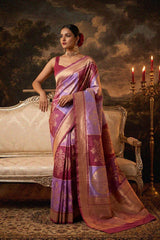 Woman in a traditional pastrel rangakt banarasi saree sitting on an ornate couch with a dramatic background