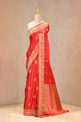 Close up of Red Semi Satin Silk Saree showing gold zari woven pakshi motifs and a Mrigvan-inspired deer and tree border.