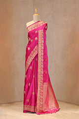 Close up of Pink Semi Satin Silk Saree showing gold zari woven pakshi motifs and a Mrigvan-inspired deer and tree border.