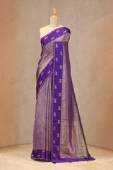 Close up of purple Semi Viscose Silk Saree showing gold zari wave brocade pattern on the body and satin border with Pichwai motifs.