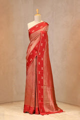 Close up of Red Semi Viscose Silk Saree showing gold zari wave brocade pattern on the body and satin border with Pichwai motifs.