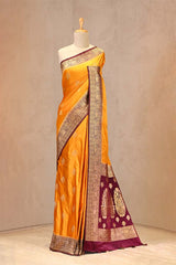 Close up of Mustard Yellow and Maroon Semi Satin Silk Saree showing gold zari woven rose buti on white body and gold zari floral patterns on contrasting pink border.