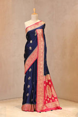 Close up of Dark Blue and Red Semi Satin Silk Saree showing gold zari woven rose buti on white body and gold zari floral patterns on contrasting pink border.