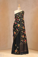 Close up of Black Semi Tussar Silk Saree showing multicolor floral embroidery on the pleats area and the pallu.