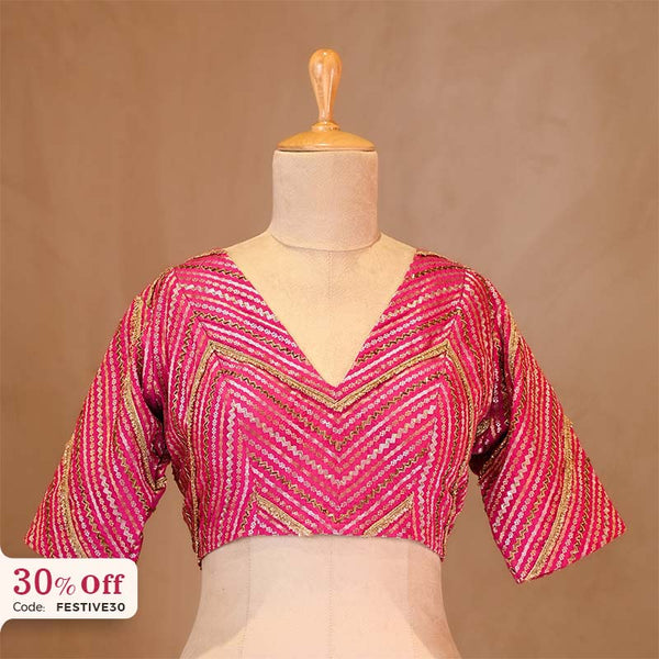 Pink patterned blouse on a mannequin with a brown background